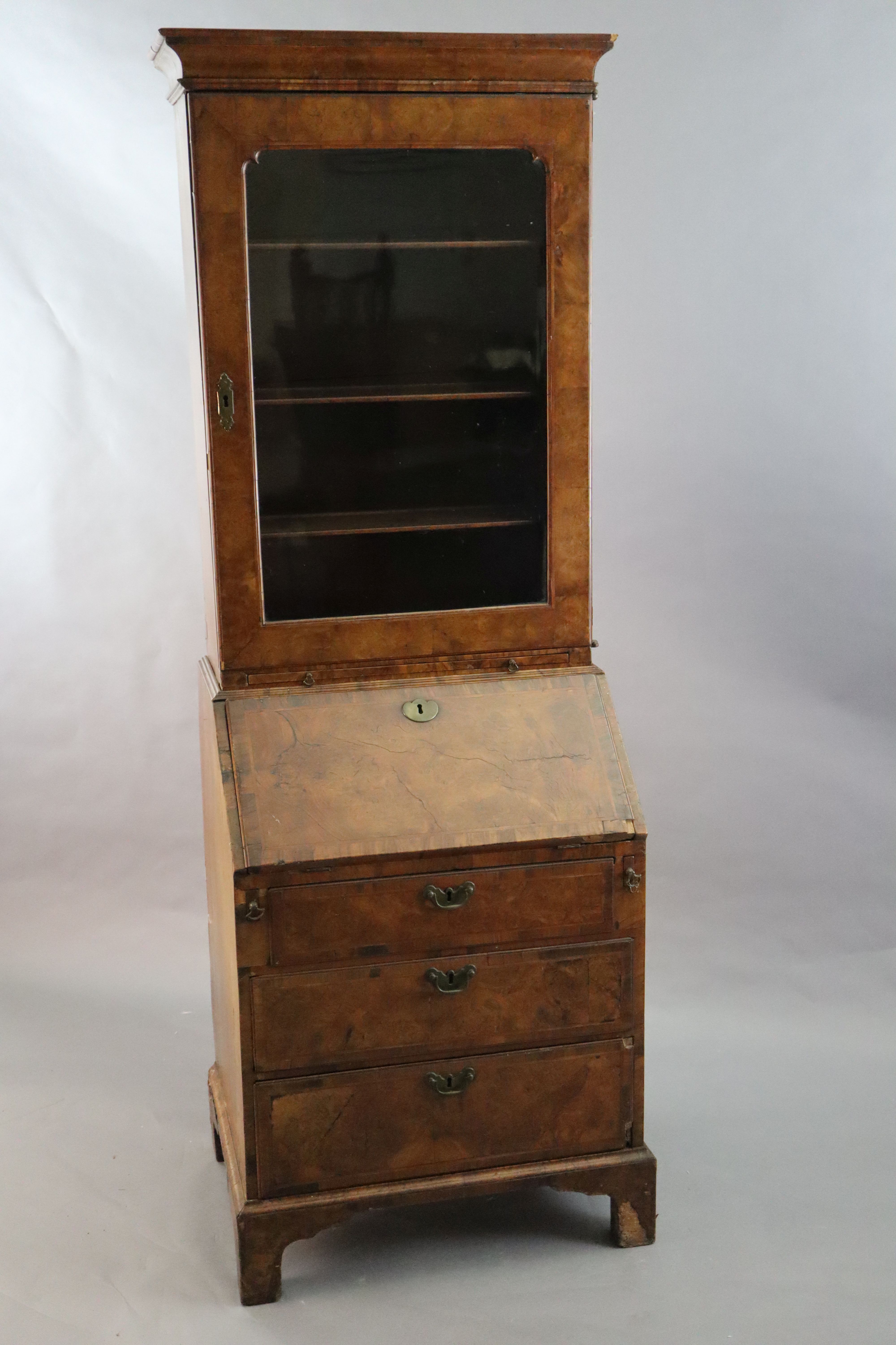 An early 18th century banded walnut bureau bookcase W. 2ft 4in. H. 6ft 6in. D. 1ft 8in.